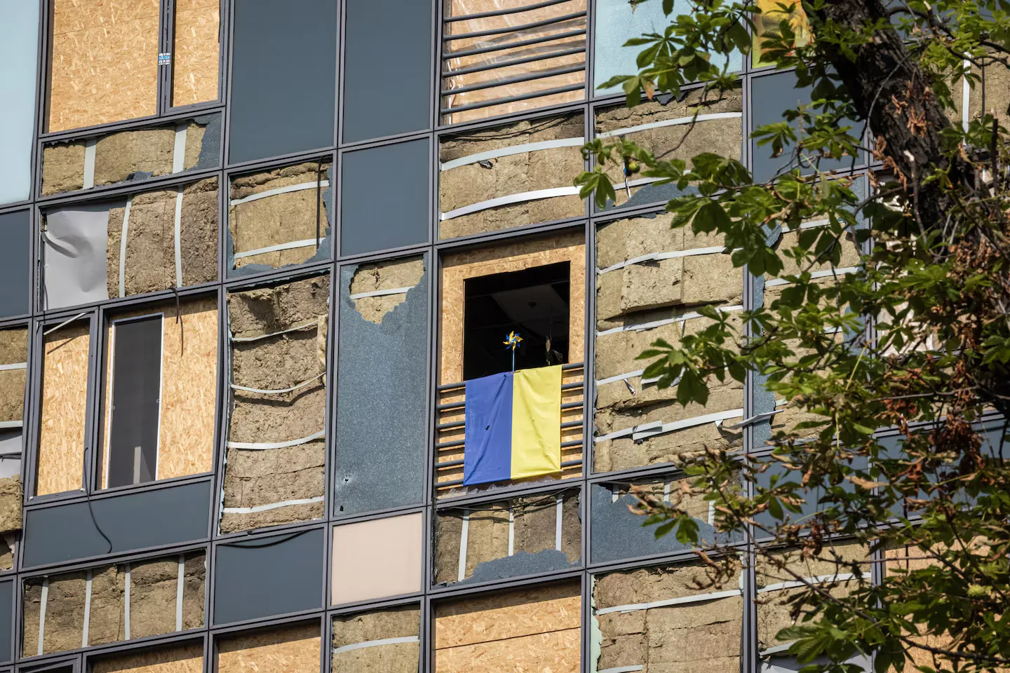 Прапор України та вертушка у вікні навпроти місця обстрілу.